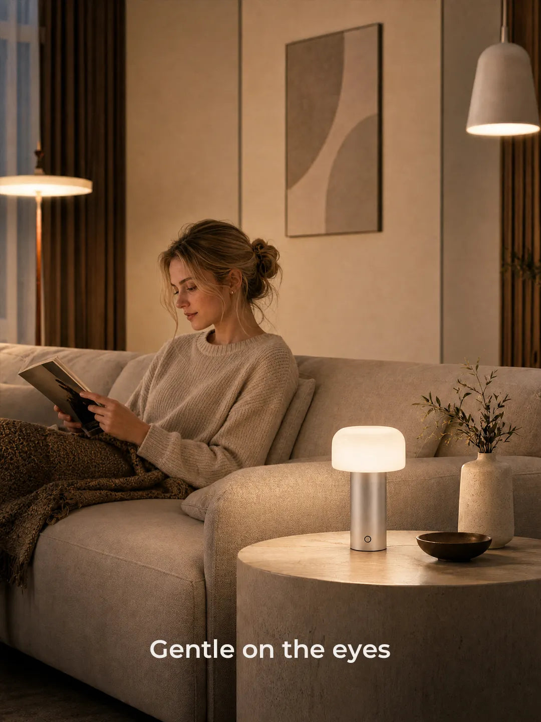 Hooled Vesper Metal Tischleuchte mit sanftem Licht in einer Leseszene auf dem Sofa