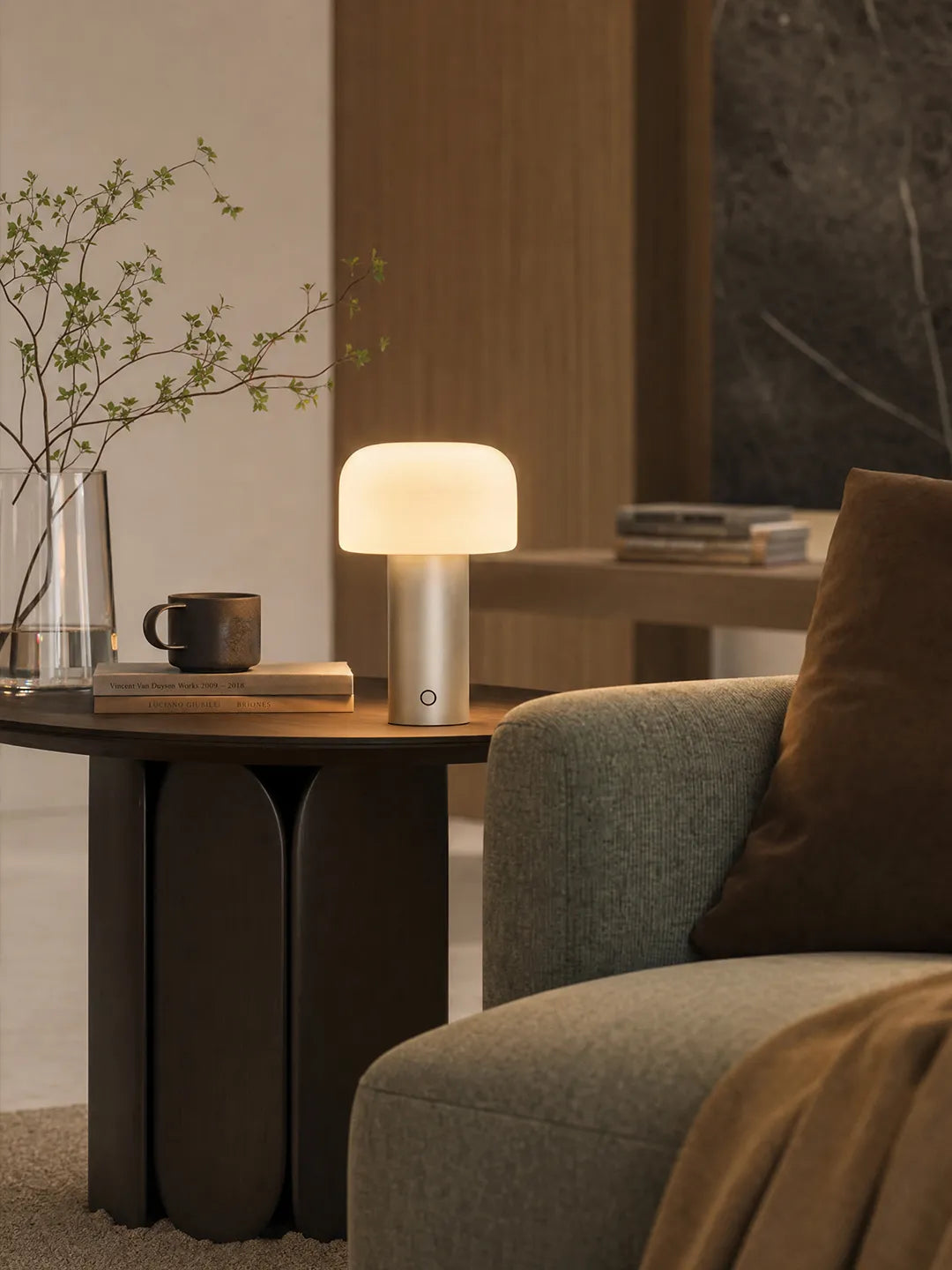 Hooled Vesper Metal Tischleuchte auf einem Beistelltisch neben Sofa, Vase und Tasse